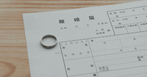 デスクに置かれた離婚届と結婚指輪