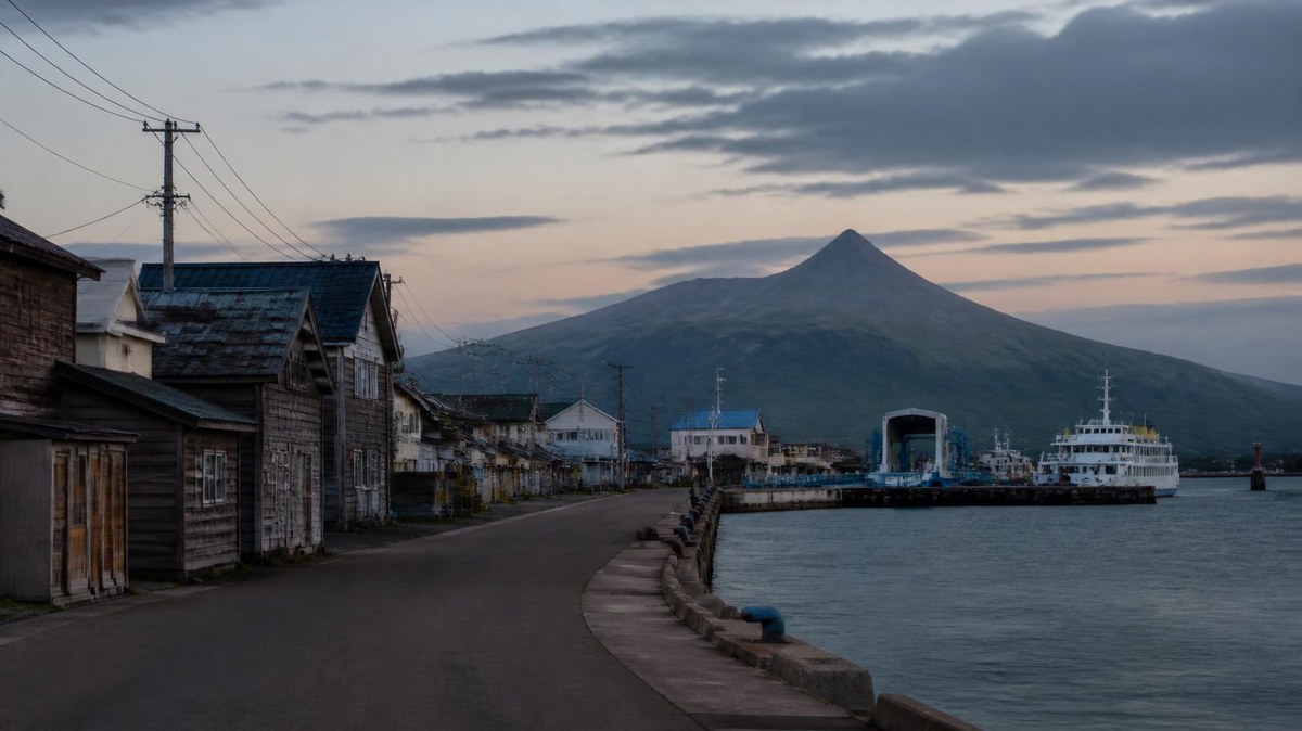 夕暮れの離島の港町と山（イメージ）