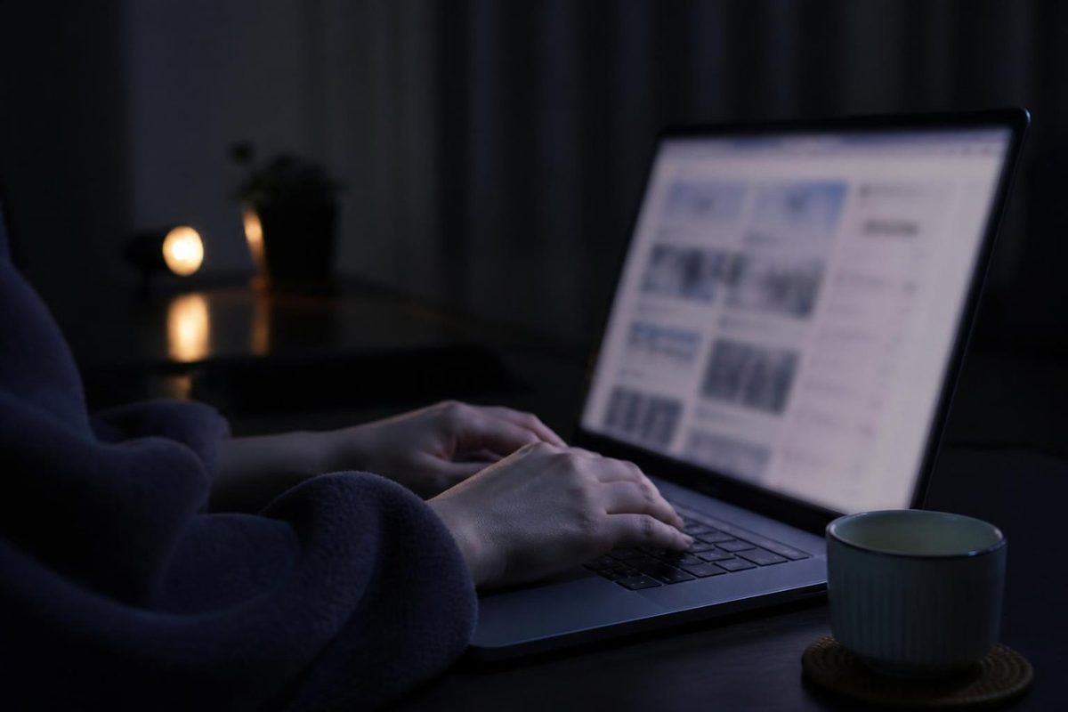 夜にノートパソコンで調べものをする手元