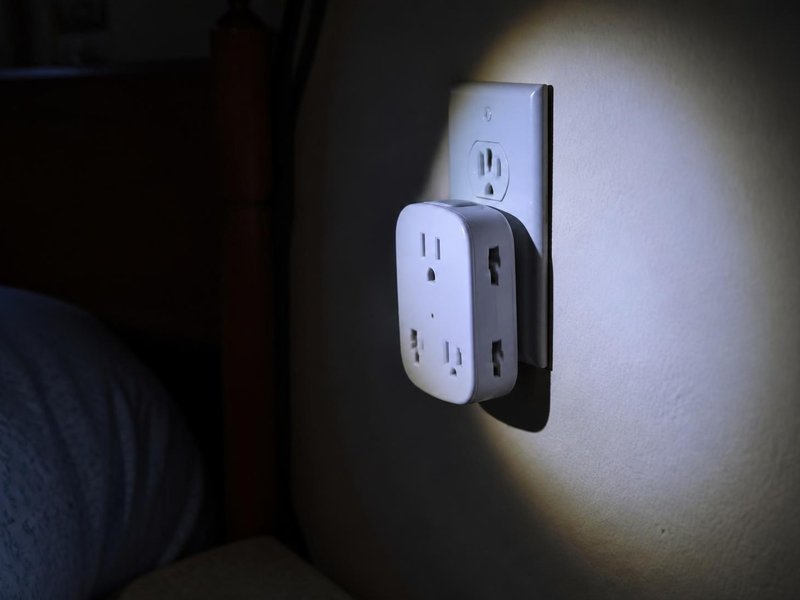 懐中電灯で照らしたコンセントの電源タップ
